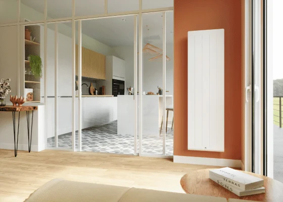 Radiateur vertical blanc posé dans le séjour d'un appartement